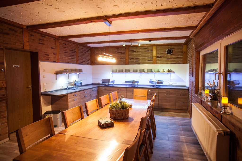 Essbereich mit langem Holztisch und Buffet an der Theke.